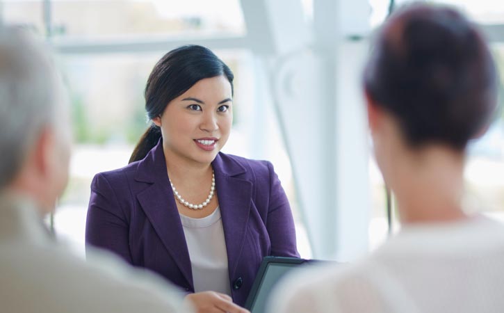 A financial advisor speaks with a man and woman.