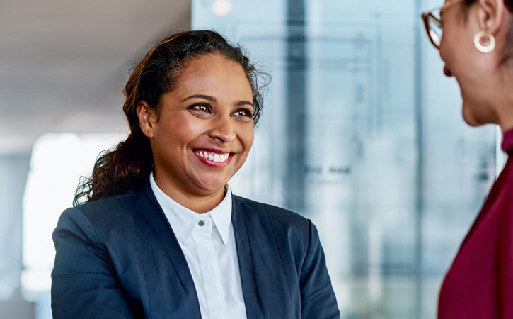 Deux professionnelles se réunissent dans un hall.