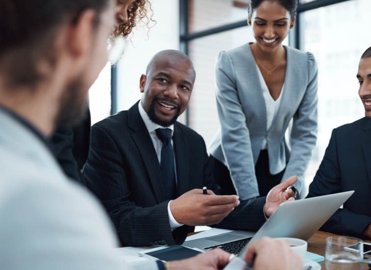 Des gens d’affaires discutent autour d’un ordinateur portable.