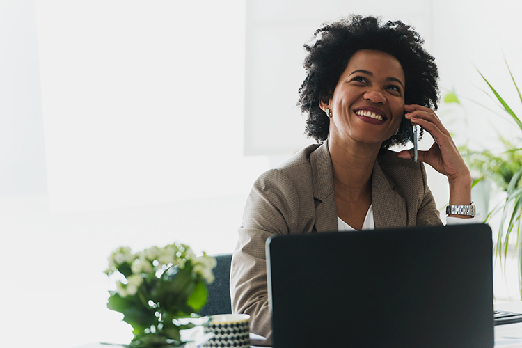 Women on phone in front of computer