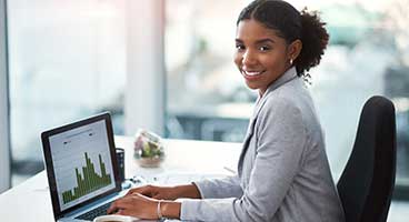 Business woman working at laptop smiling